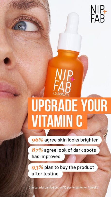 Woman in her 40's smiling and holding an orange bottle of Nip and Fab Illuminate